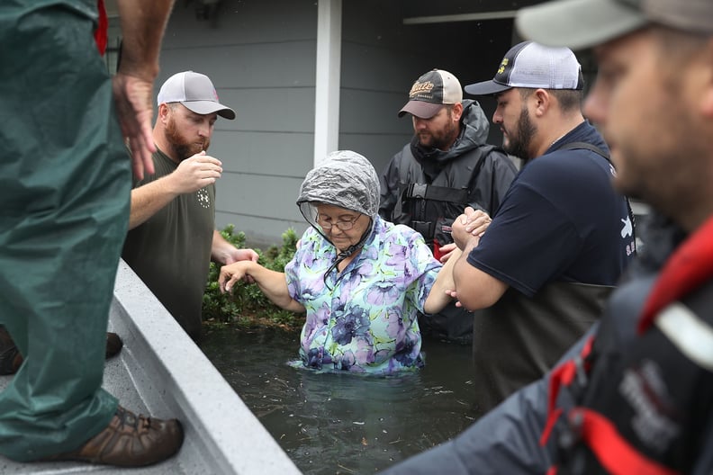 A woman is rescued from her flooded home in Port Arthur, TX.
