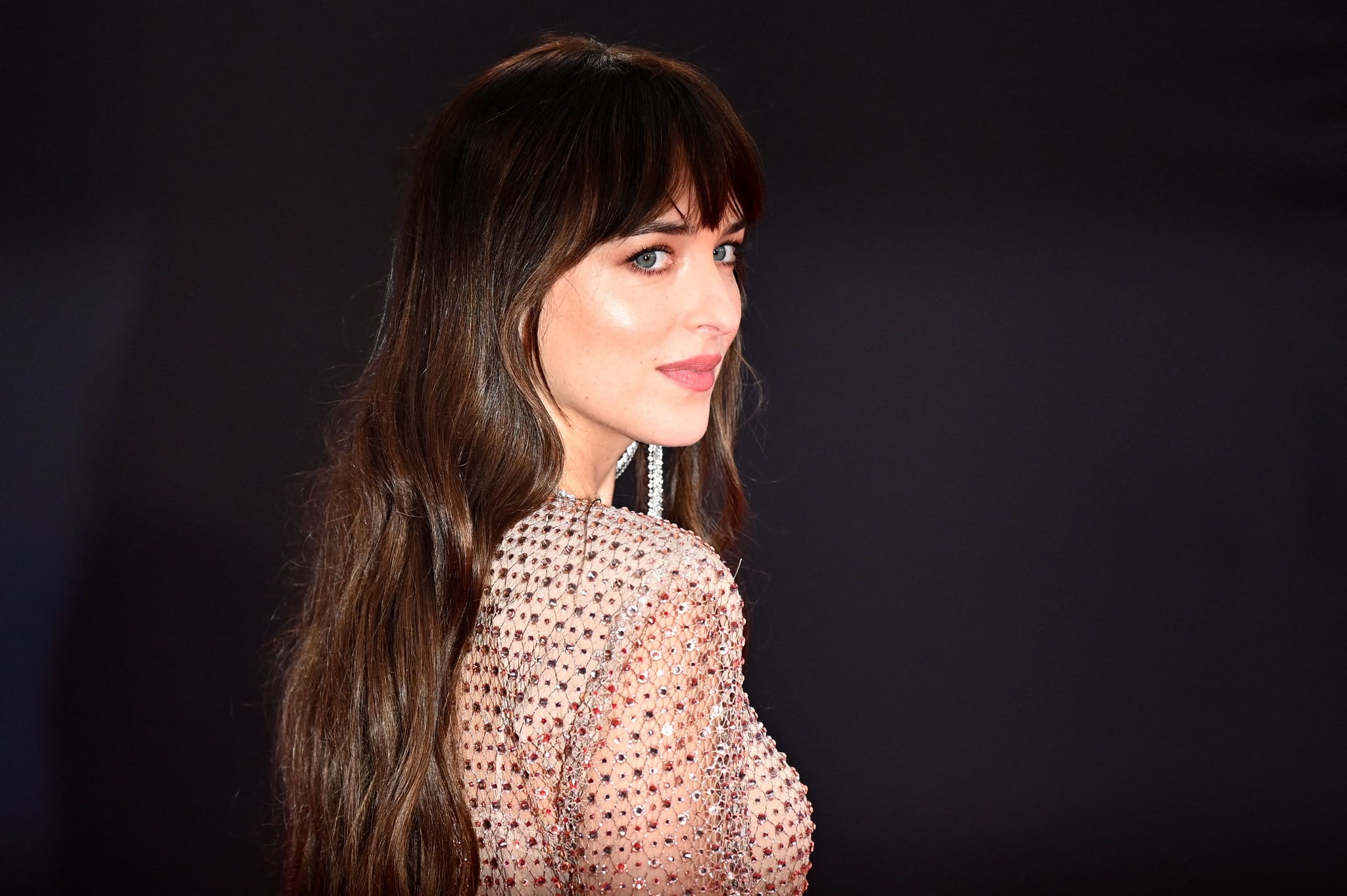 TOPSHOT - American actress Dakota Johnson poses on the red carpet on her arrival to attend the European premiere of the film 'The Lost Daughter', during the 2021 BFI London Film Festival in London on October 13, 2021. (Photo by JUSTIN TALLIS / AFP) (Photo by JUSTIN TALLIS/AFP via Getty Images)
