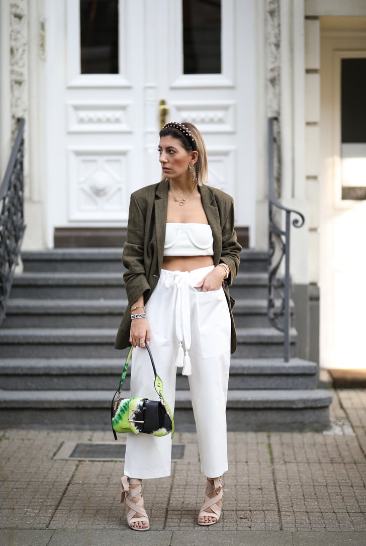 Style a white crop top with matching pants and a green ...