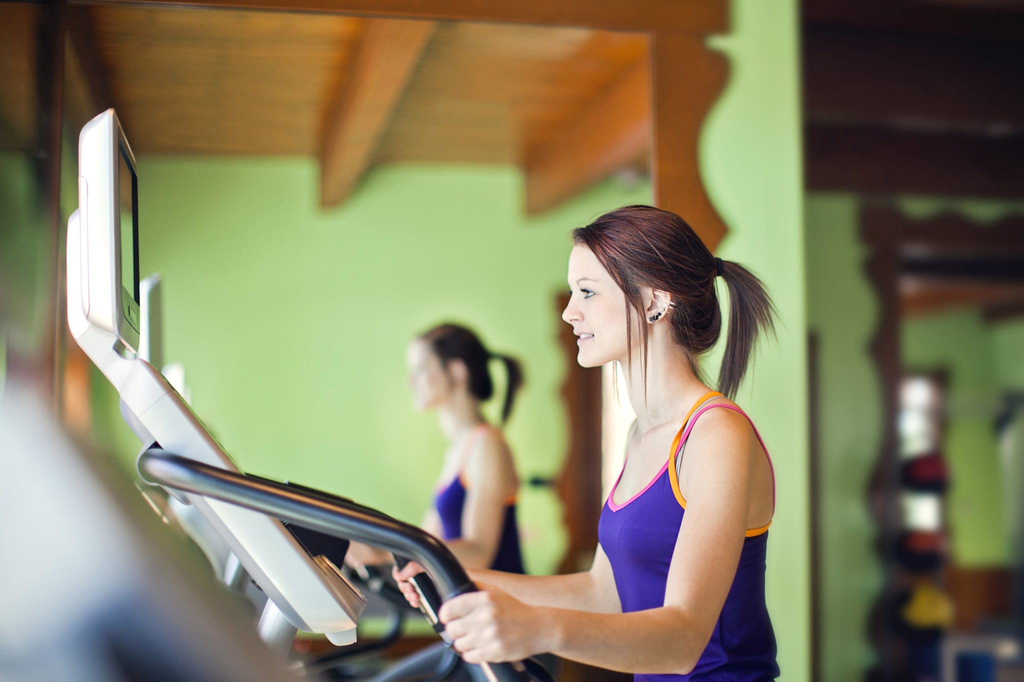 Girl uses stationary stair climbing machine.