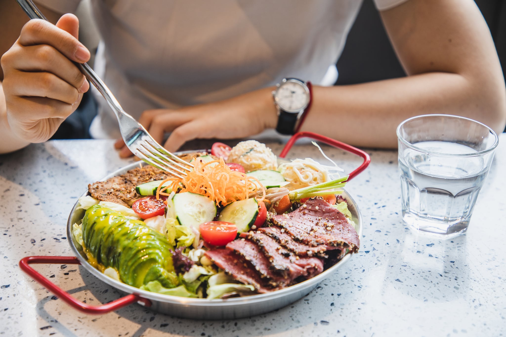 Woman enjoying healthy fruit, vegetable and meat salad with balance nutrition.
