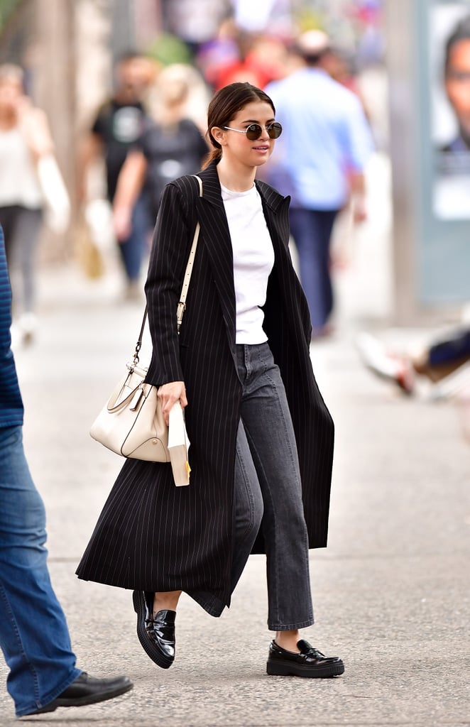 A good coat instantly dresses up any outfit and Selena's pinstripe duster Norma Kamali trench did exactly that. She wore it with a pair of cropped black jeans, a t-shirt, and chunky leather loafers by Tod's.