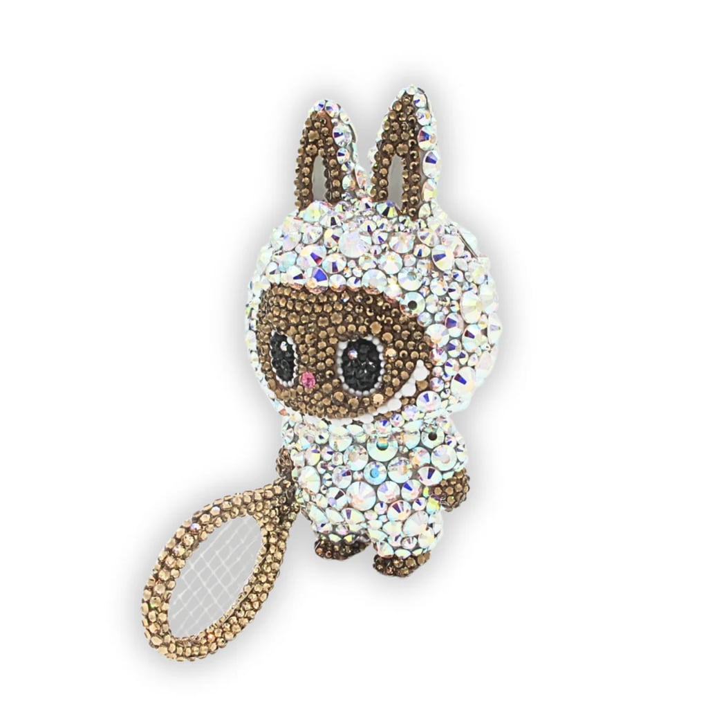 A-Morir Althea Glitterson Labubu ($525)
If you too were influenced by Naomi Osaka's stunning Labubu collection, pick up her exact crystal-covered charm from A-Morir. Covered in premium crystals, the accessory pays homage to legendary pioneering athlete Althea Gibson with its white tennis outfit and wooden racquet.