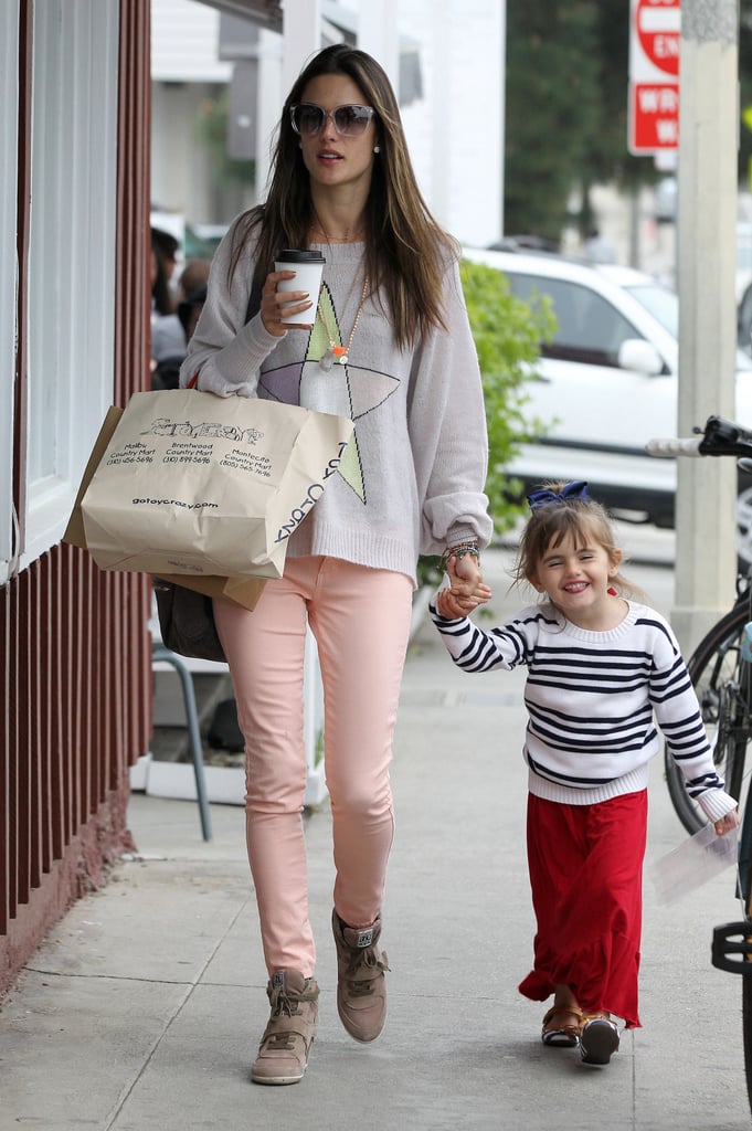 Alessandra Ambrosio worked salmon-pink jeans with Ash wedge sneakers and a star-print sweater while on mommy duty in LA.