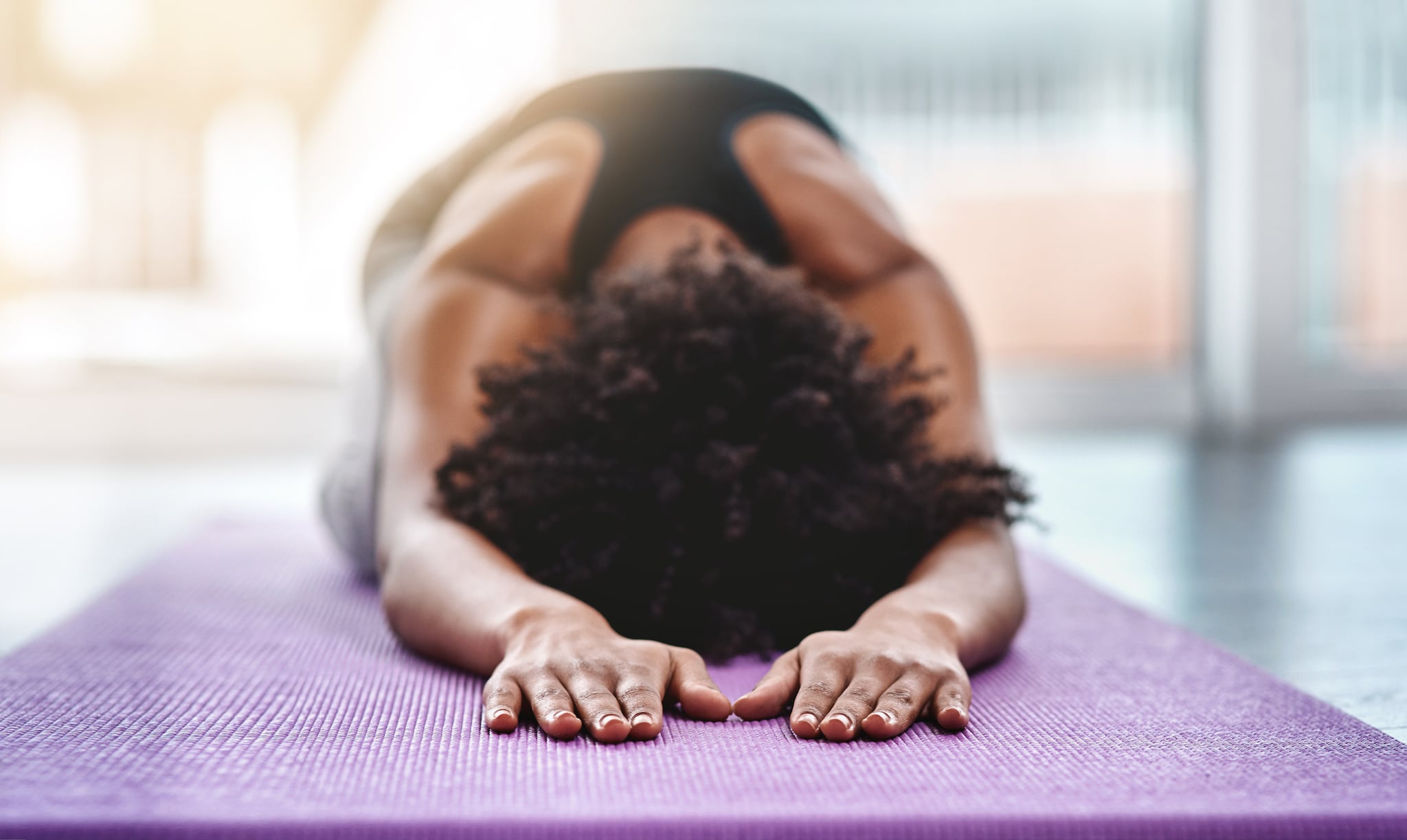 Shot of a beautiful young woman practising yoga in a studio