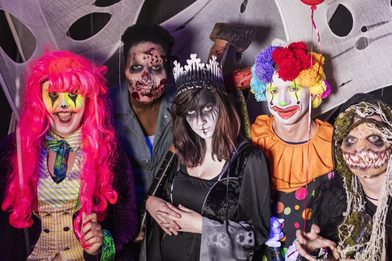 A group of young adults dressed in scary halloween costumes, zombies, demons, ghouls and a clown. They are working in a haunted house, ready to scare any trespassers.
