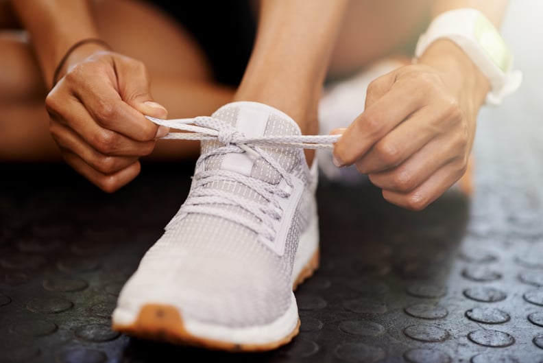 Cropped shot of a woman tying the shoelaces of her sports shoe