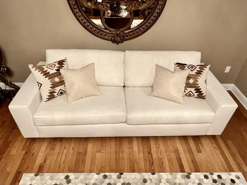 The Albany Park Barton Sofa in Sand Basketweave fabric with throw pillow on it.