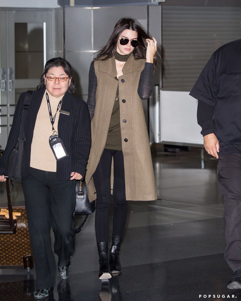Kendall rocked her black leather Givenchy bag at the airport with a longline vest, an olive top, skinny jeans, and boots.