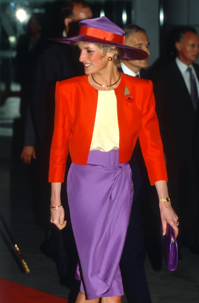 30 years prior, While visiting Hong Kong in 1989, Princess Diana wore the exact same colour combination. The look consisted of a purple-and-red suit designed by Catherine Walker and a wide brim hat of the same tones, along with gold accessories and a purple metallic purse to match.