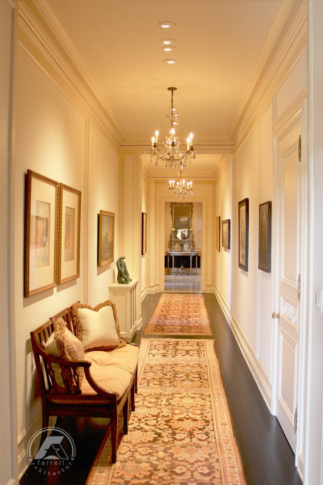Beautiful molding, hardwood floors, and elegant lighting fill the hallway.