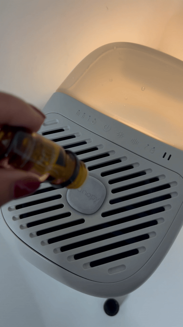 Dropping essential oils in the fragrance well of the Canopy Bedside Humidifier 2.0.