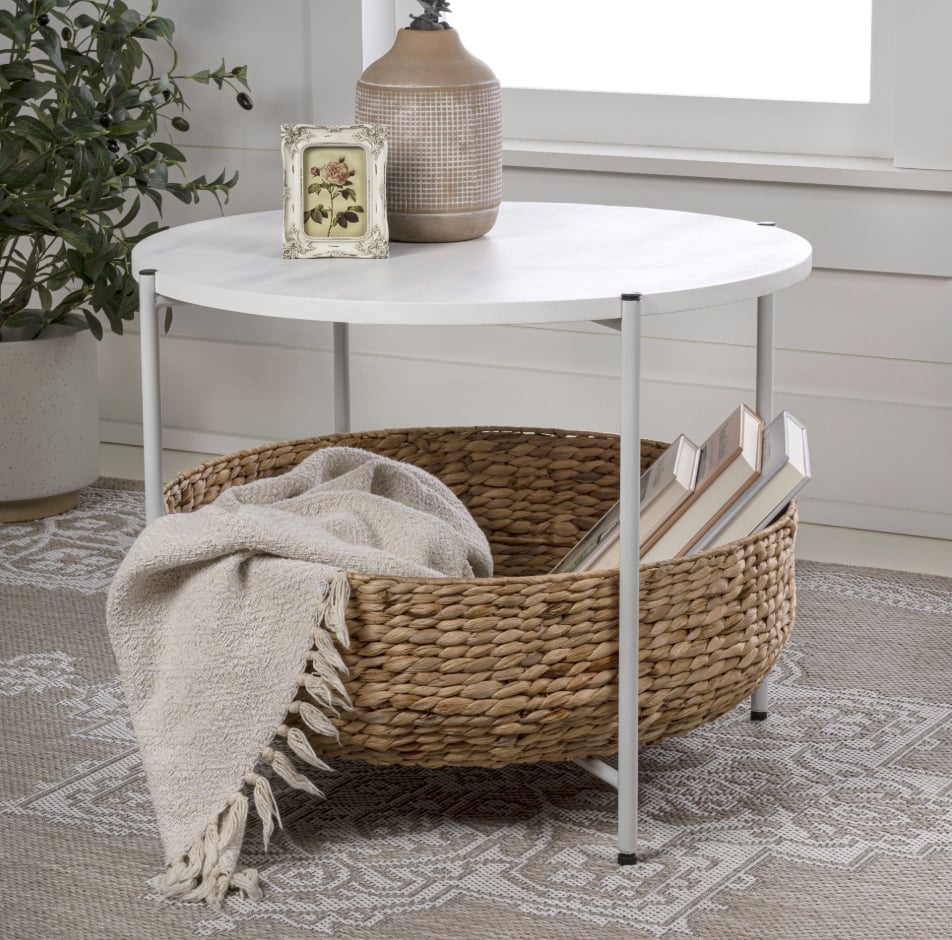 Happimess Carly Modern Coastal Round Coffee Table ($160)
There's nothing better than a furniture piece that doubles as a storage spot, and this small, space-friendly coffee table certainly fits the bill. Complete with a woven basket shelf underneath, it's perfect for books, blankets, remotes, and more — a two-for-one, if you will.