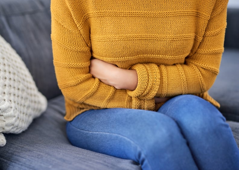 Closeup shot of a woman suffering with stomach cramps at home