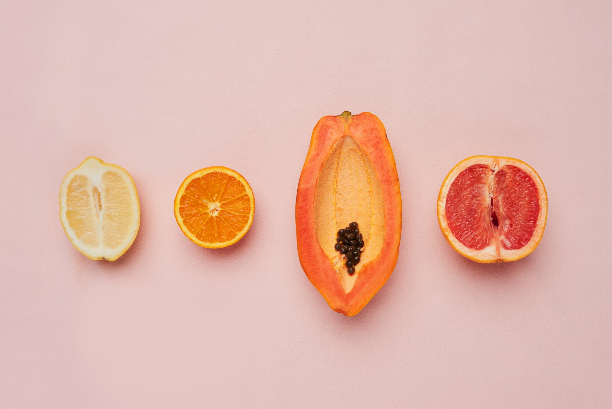 Studio shot of a row of fruit against a pink background