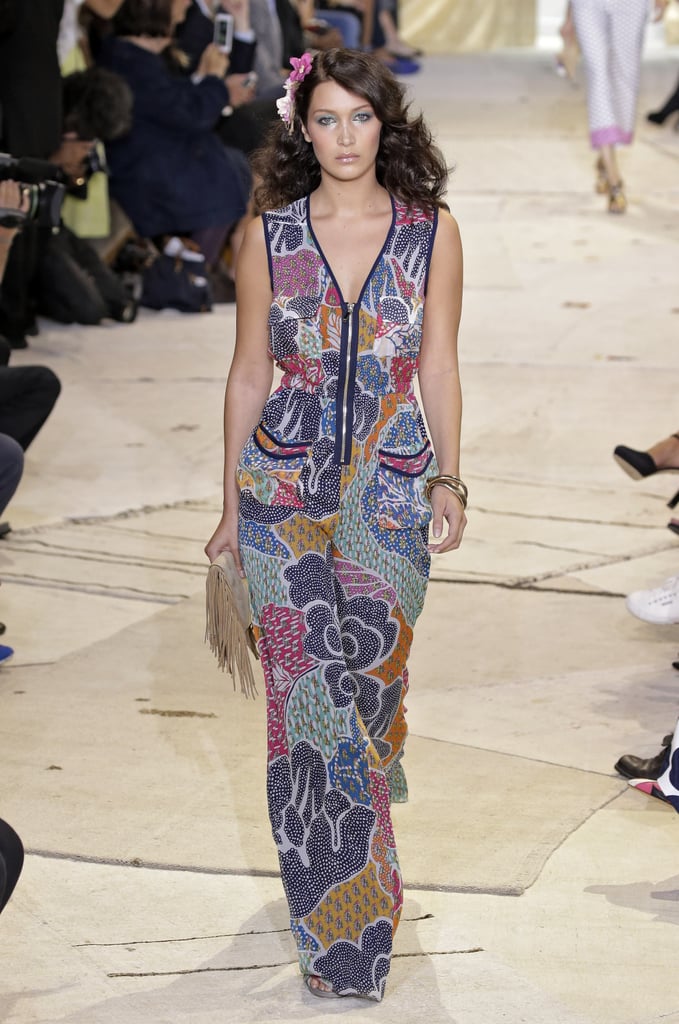 Bella's look was a bit more playful: a wide-leg, zipper-adorned jumpsuit printed with a colorful pattern. Her design was accessorized with a neutral fringe clutch and a stack of bangles.