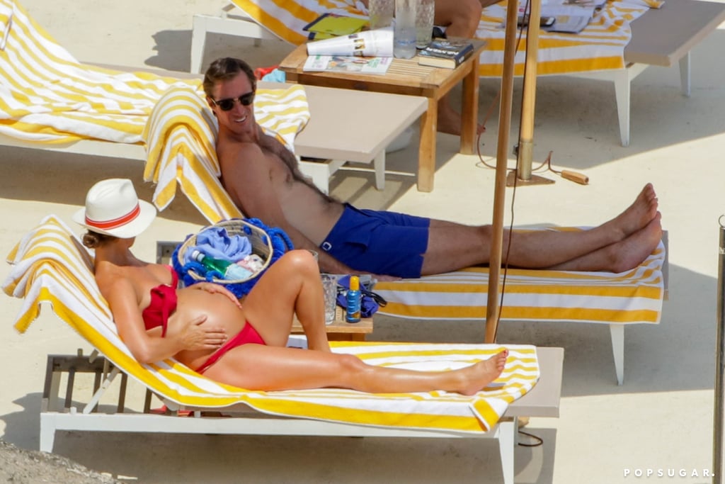 Pippa rubbed her belly as the couple relaxed on beach chairs.