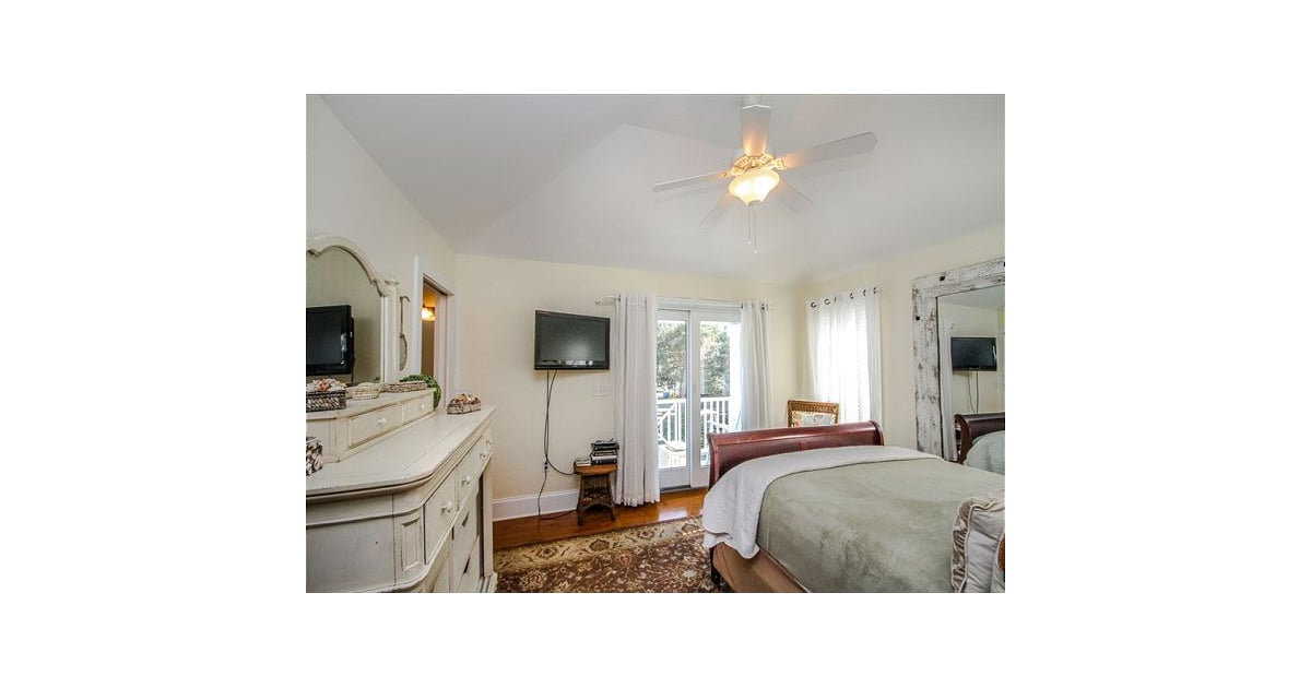 The cozy master bedroom has a private balcony and a wall-mounted TV. | Rent Paula Deens Georgia Beach House | POPSUGAR Home... 