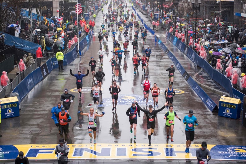 Runners come to the finish line of the 122nd Boston Marathon, where rain and high winds battered down for the duration. Monday April 16, 2018.  / AFP PHOTO / RYAN MCBRIDE        (Photo credit should read RYAN MCBRIDE/AFP/Getty Images)