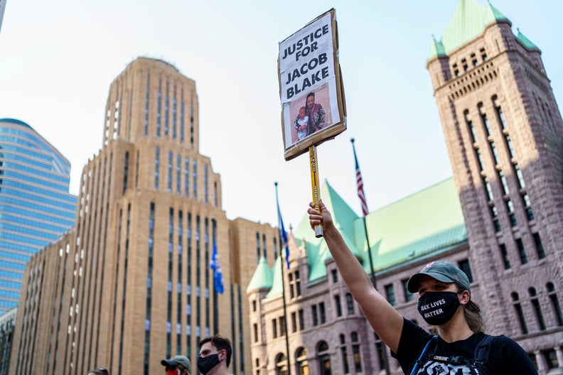 TOPSHOT - A protester holds sign outside at Hennepin County Government Plaza, during a demonstration against police brutality and racism on August 24, 2020 in Minneapolis, Minnesota. - It was the second day of demonstrations in Kenosha after video circula