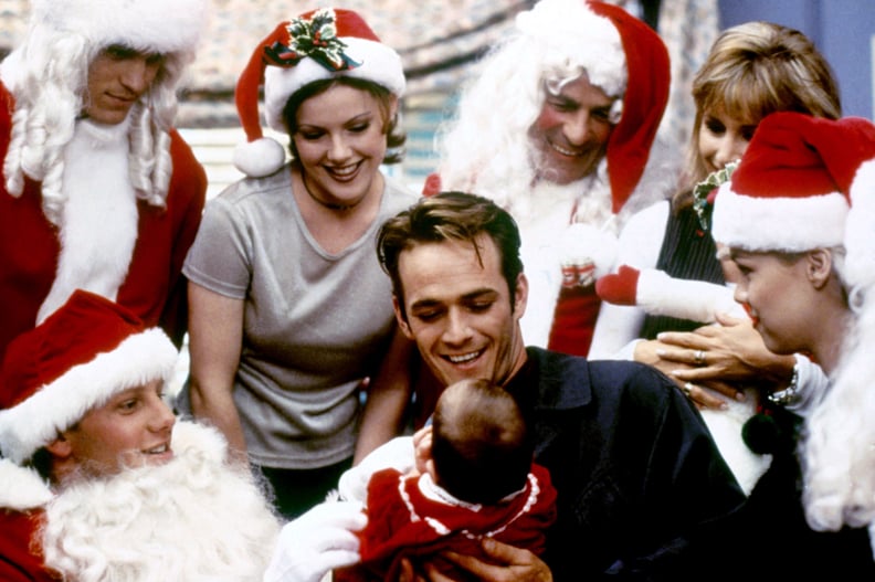 Luke Perry Holding a Baby Surrounded by Santas
