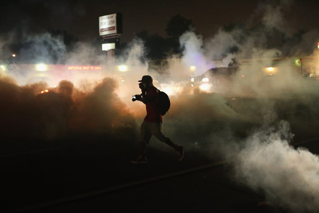 A person ran through the smoke after police launched tear gas in Ferguson, MO. A person ran through the smoke after police launched tear gas in Ferguson, MO.