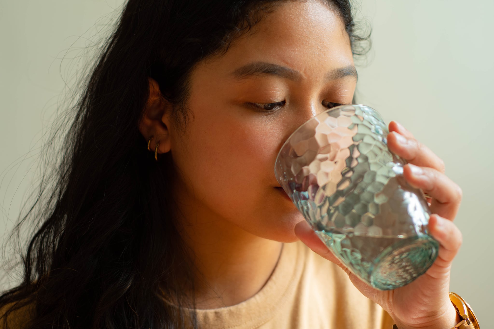 A woman in pain while drinking water.