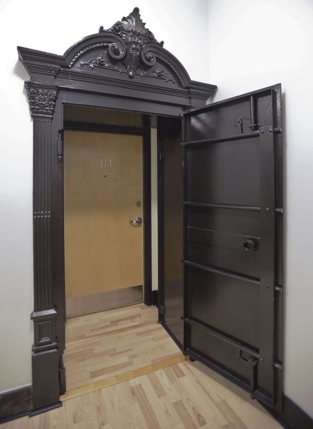 We love how the original cast-iron vault door was preserved to stand as the apartment entrance.