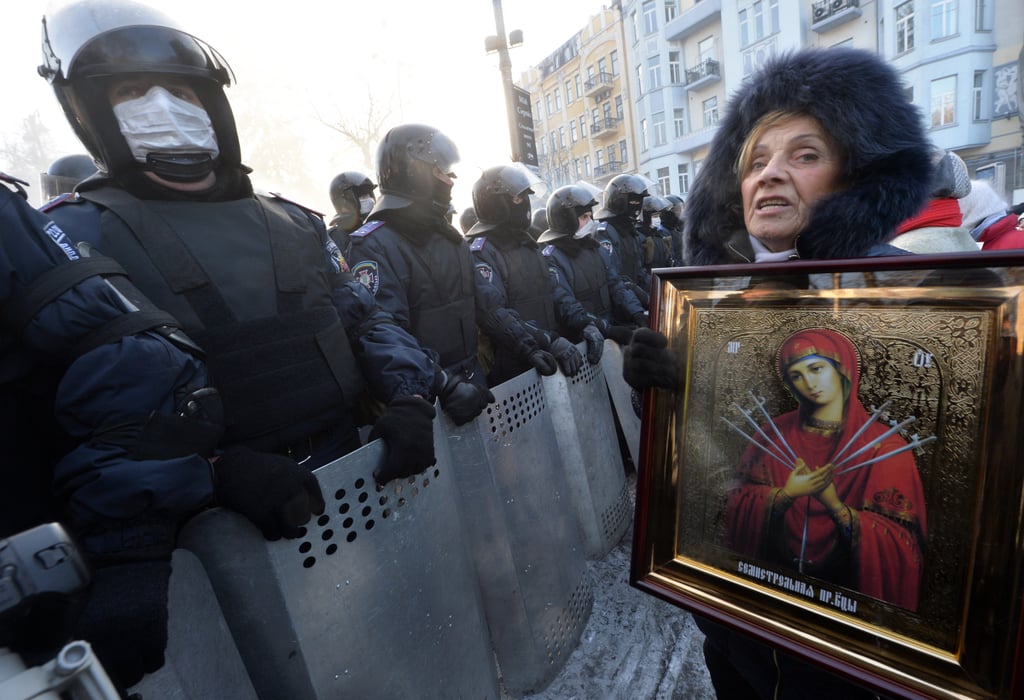 One woman held up a religious image while standing in front of riot police in Kiev.