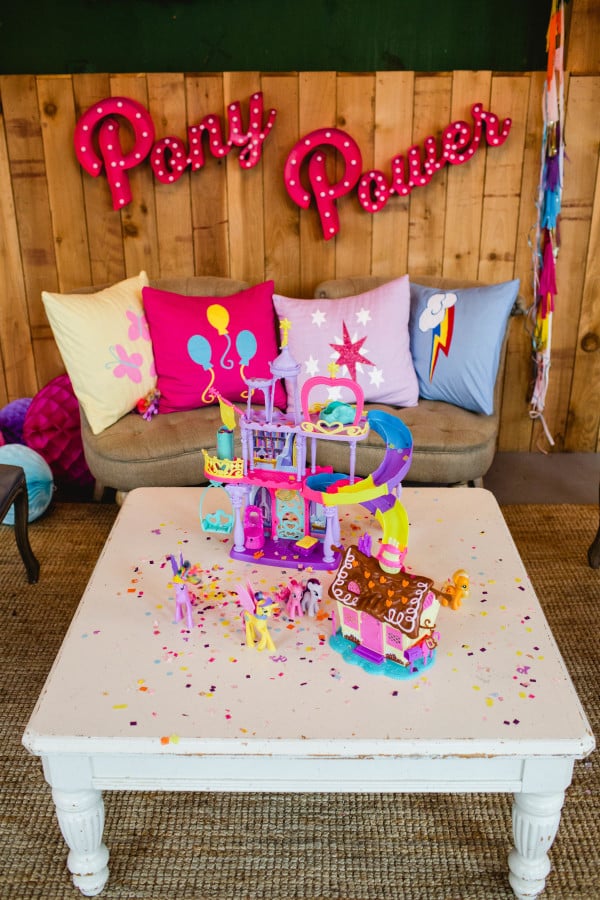 Another decor detail I love is creating custom pillows for my parties.  I connected with So Vintage Chic to create pillow covers with the My Little Pony cutie marks.  They knocked it out of the park!  They were absolutely perfect!  (These too are in Ally’s room, ha!  Never underestimate finding a permanent home in your home for your party decor!)
One of my goals with this theme was to be resourceful and use some of Ally’s My Little Pony toys as decor and details.  If your child wants a party theme after a specific toy they already own, find a way to use it!  Why spend extra money on party decor when you can pull from your toy box.  We used her Princess Twilight Sparkle Castle and Pinkie Pie Playsets on the coffee table as decor that also doubled as an activity table.  It was perfect for our pint sized guests who were a bit too young for some of our party activities.