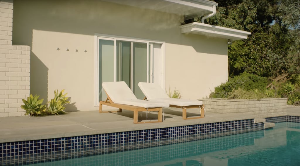 White padded lounge chairs face the pool.