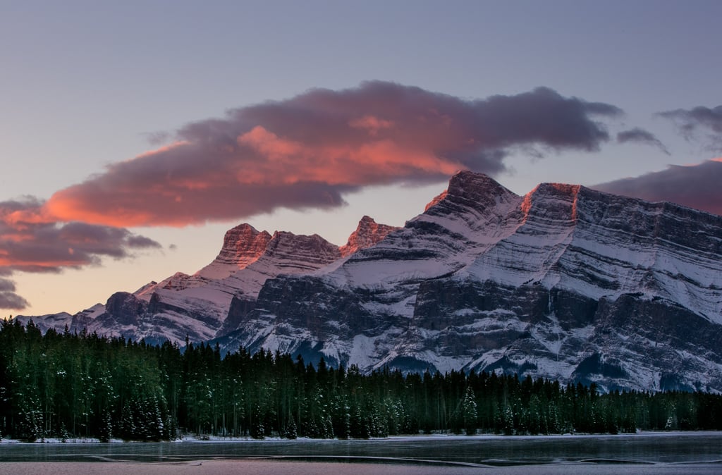 A sunrise in Canada's Alberta province reflected on the snowy mountains.