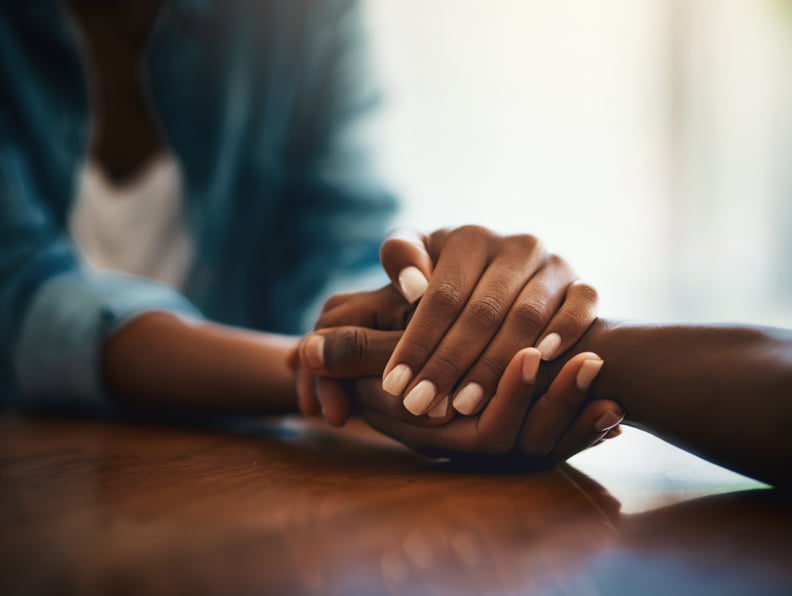 Closeup shot of two people holding hands in comfort