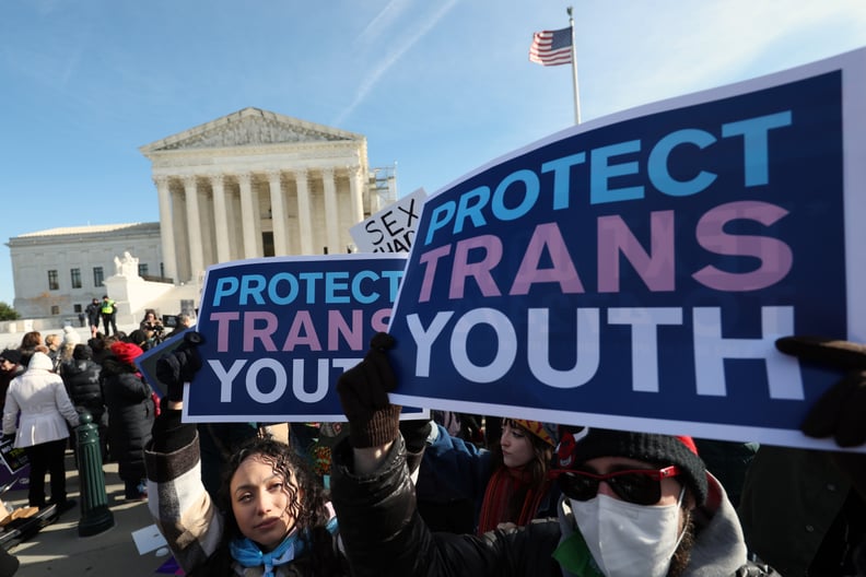 Transgender rights supporters and opponent rally outside of the U.S. Supreme Court; signs reading protect trans youth are held by protesters.