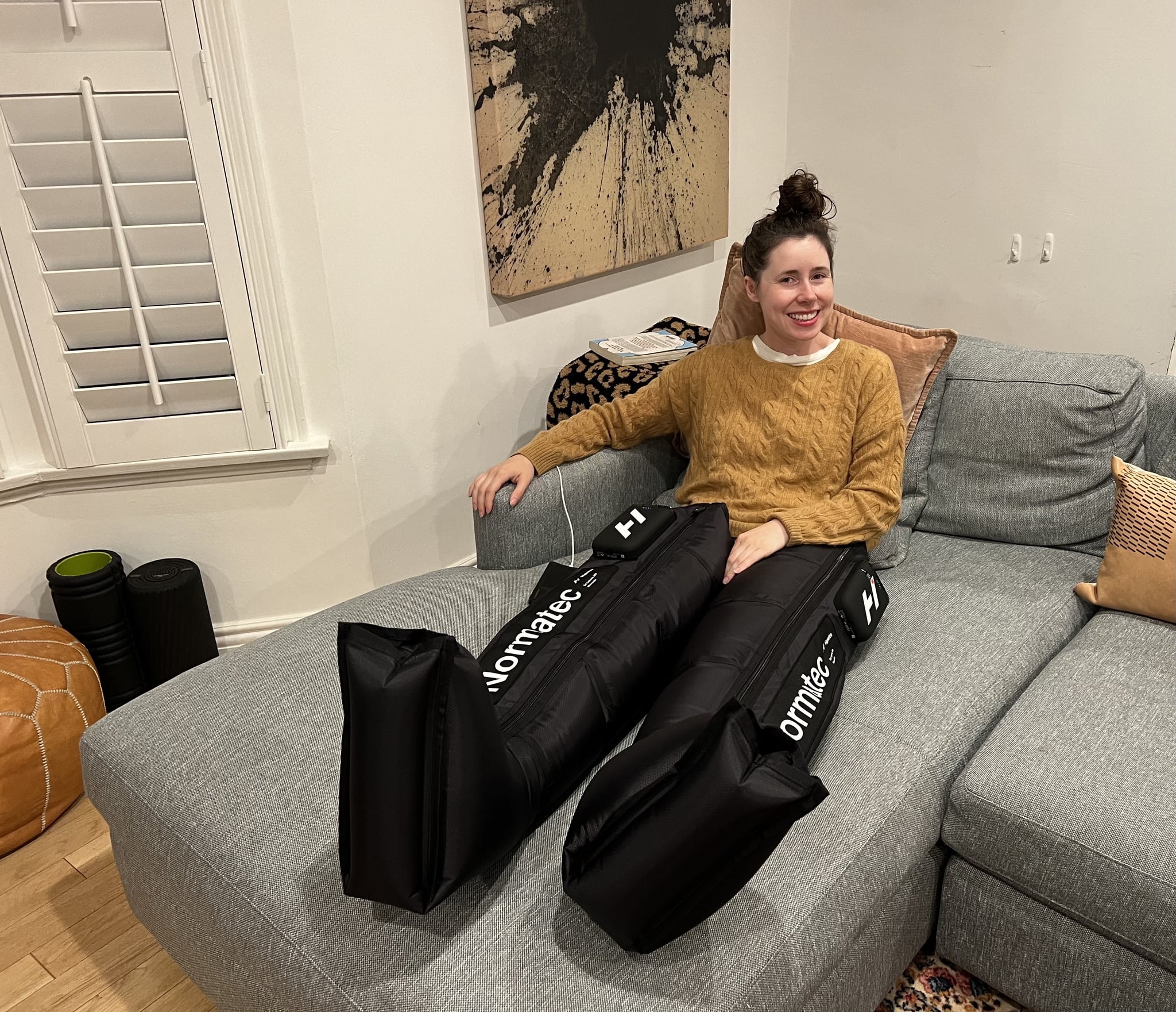 A photo of a woman wearing Normatec Elite Compression Boots.