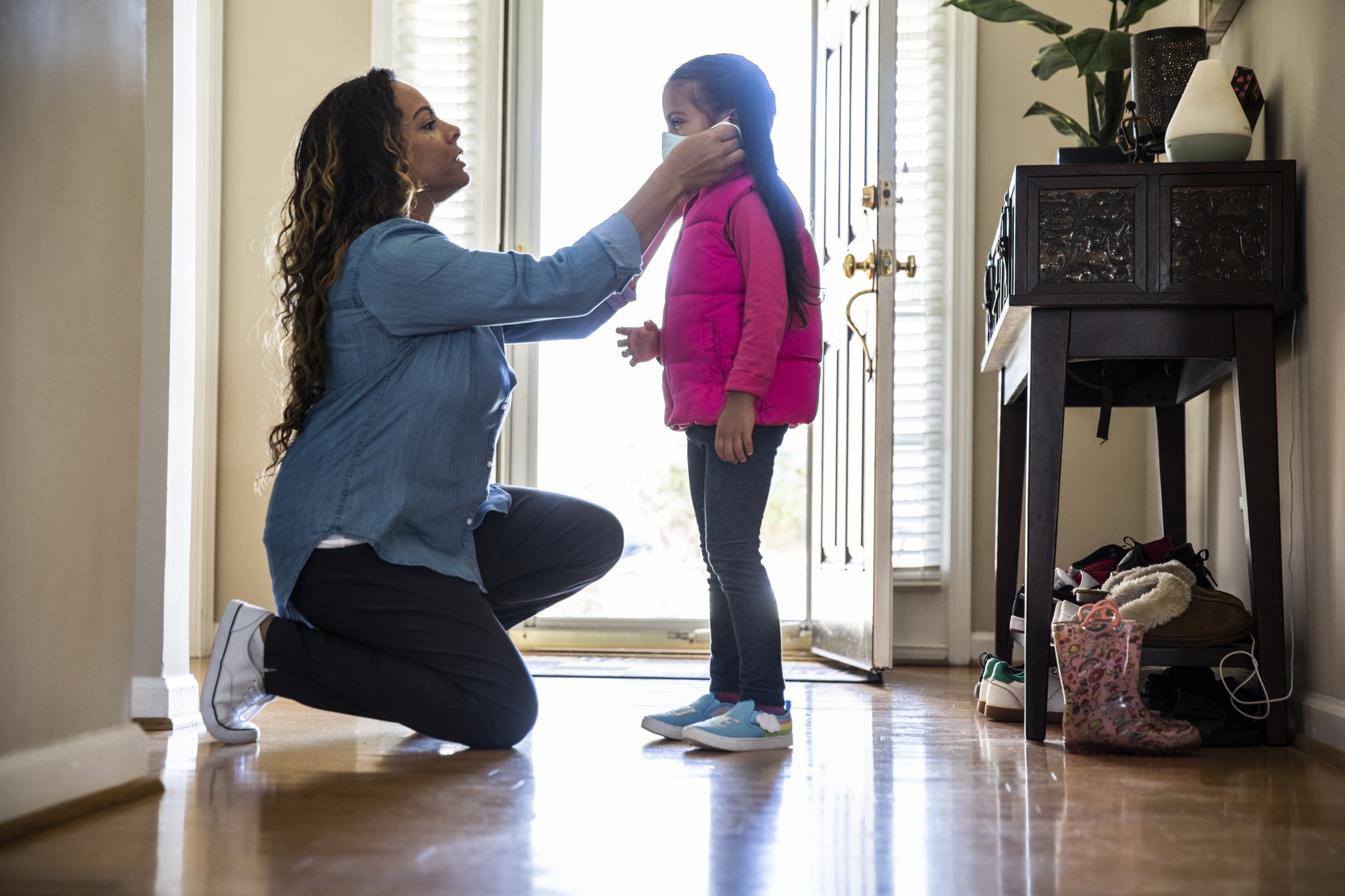 Mother putting mask on daughter