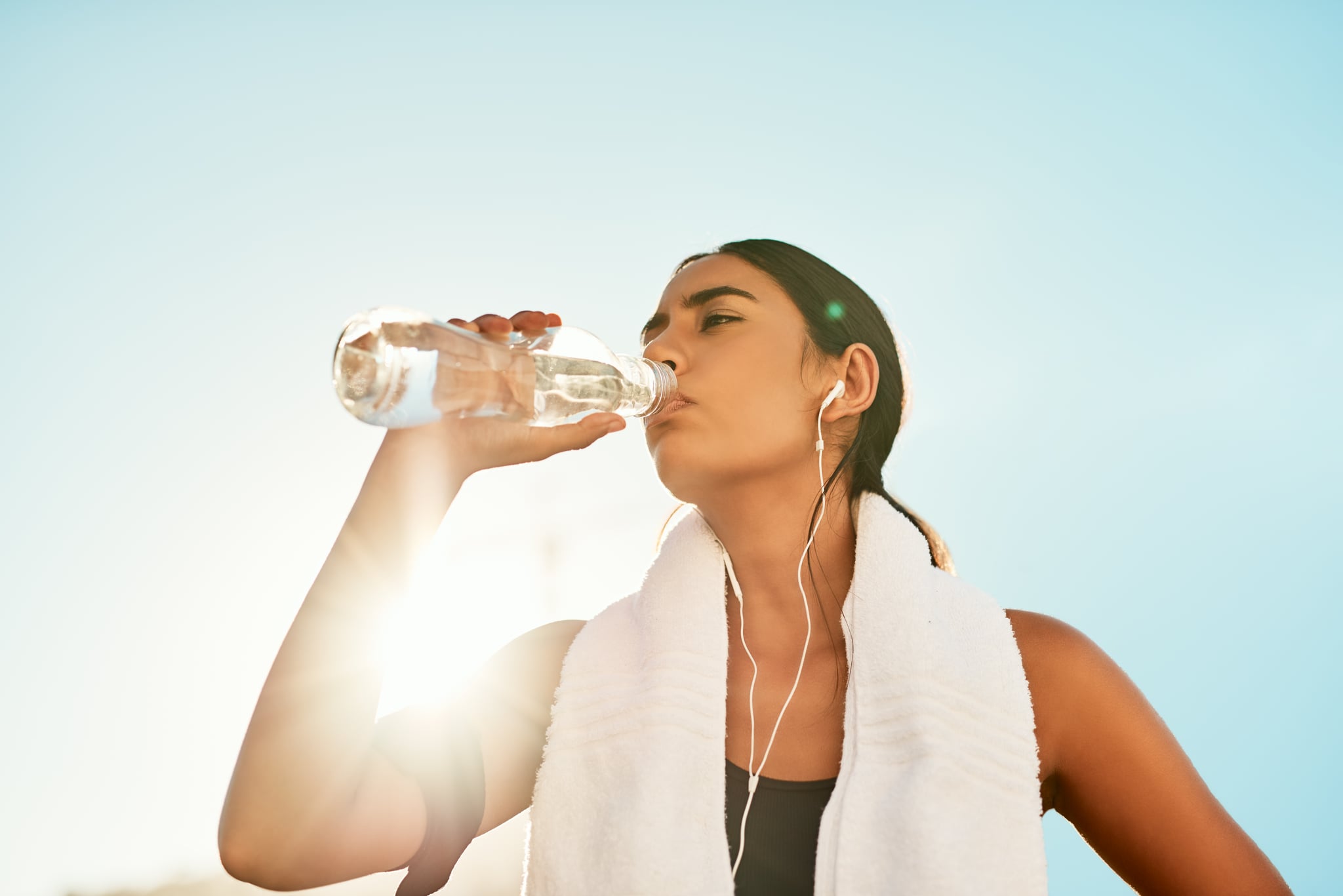 Shot of a sporty young woman taking a break while exercising outdoors