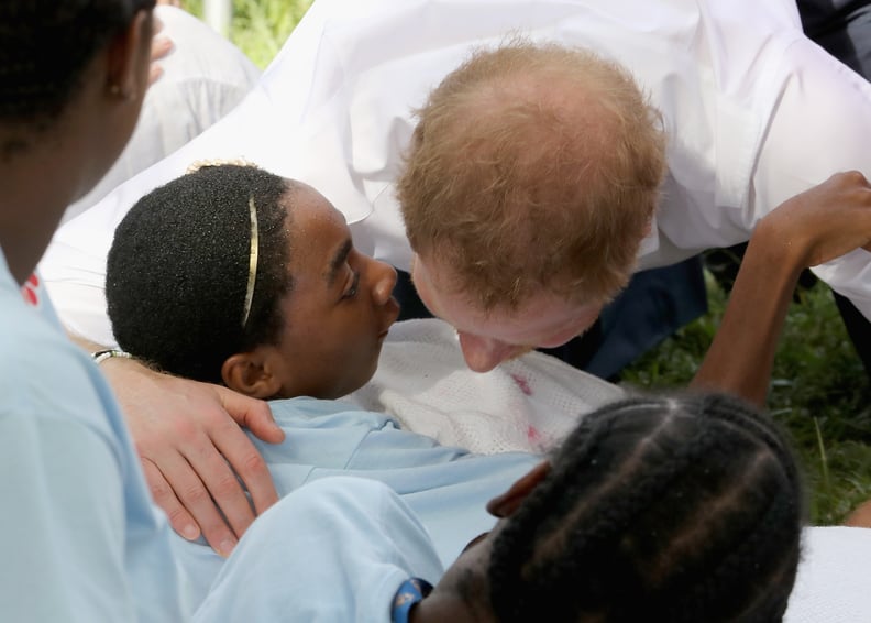 Harry hugged a young child at a Charities showcase at Government House in Antigua in 2016.