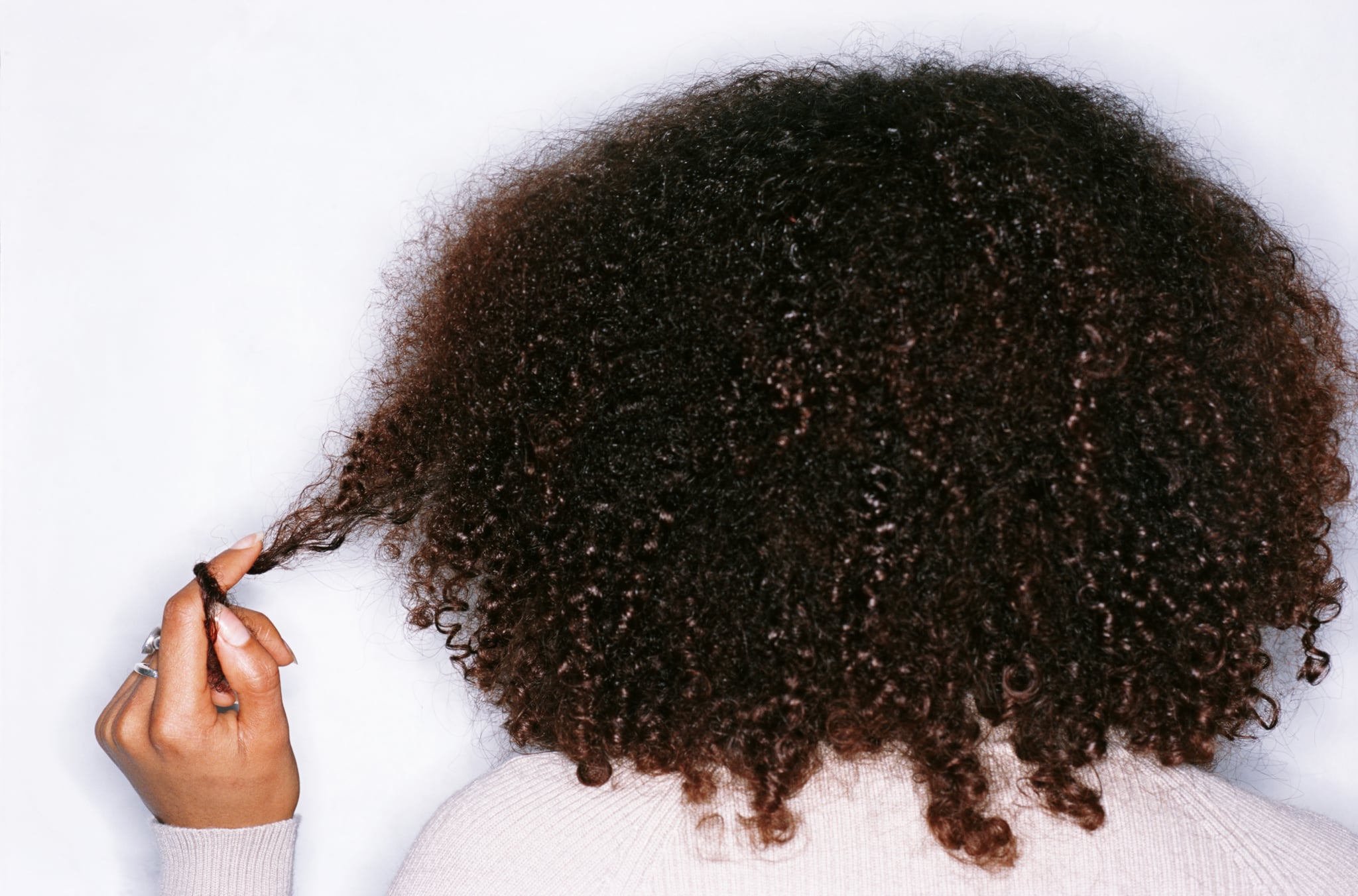 Woman twists curls after learning how to plop curly hair