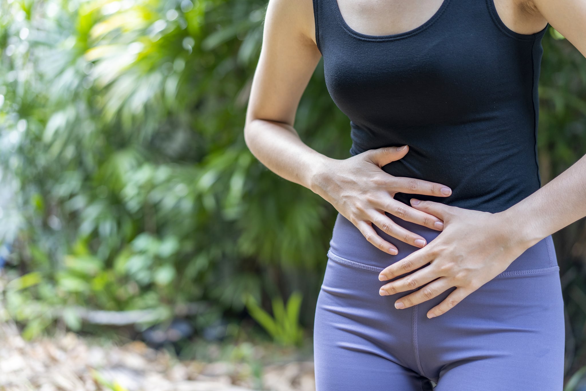 woman holding her stomach because she's bloated after a workout