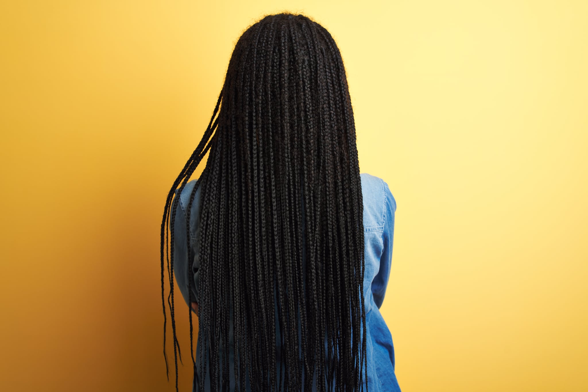 Young african american woman wearing denim shirt standing over isolated yellow background standing backwards looking away with crossed arms