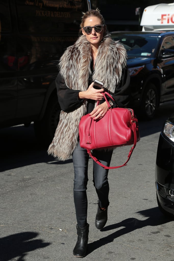Olivia accessorized her all-black separates with a cherry-red Louis Vuitton duffel and tortoise sunglasses.