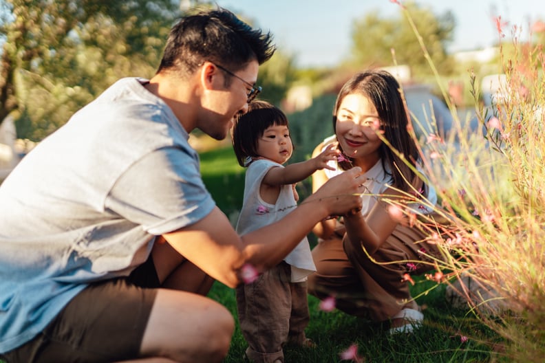 young parents spending time with their toddler in a garden