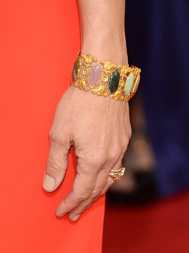Julia Louis-Dreyfus added a multicolored jeweled cuff to her bright red Narciso Rodriguez gown.