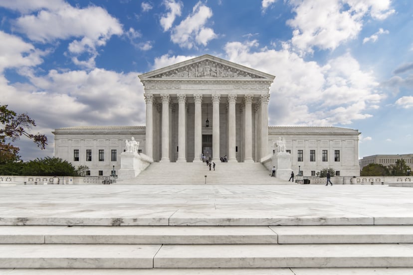 Taken at a moment when only a handful of people were in the scene, this straight-on image of the US Supreme Court shows the majesty of the structure. Home to the most powerful lawmakers in the country, this iconic building is centered under a blue sky wit