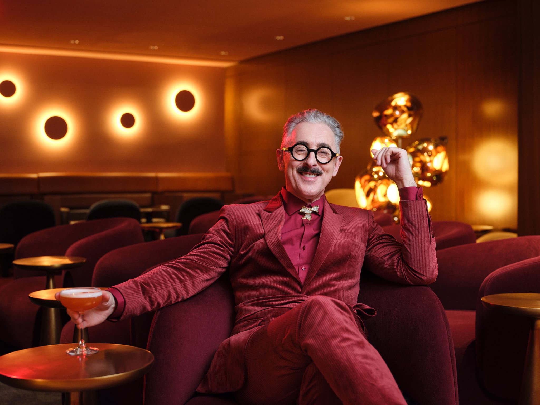 Alan Cumming sitting in a Virgin Atlantic Clubhouse lounge