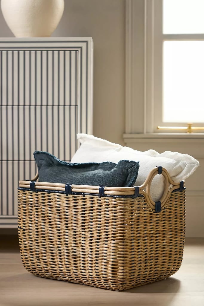 Anthropologie Round-Handed Rectangular Basket ($198)
To maximize storage in tight spaces, opt for a container with a sturdy base rather than a flexible edge. That way you can guarantee it will always fit in its designated spot in your home. This rectangular basket from Anthropologie, for example, is made out of rattan to retain its shape and is deep enough to store multiple pillows and throw blankets.