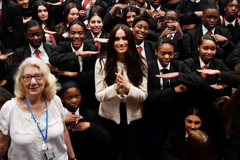 LONDON, ENGLAND - MARCH 06: (EDITOR'S NOTE: Alternative crop of image #1205706931) Meghan, Duchess of Sussex poses with school children making the 'Equality' sign following a school assembly during a visit to Robert Clack School in Dagenham to attend a sp