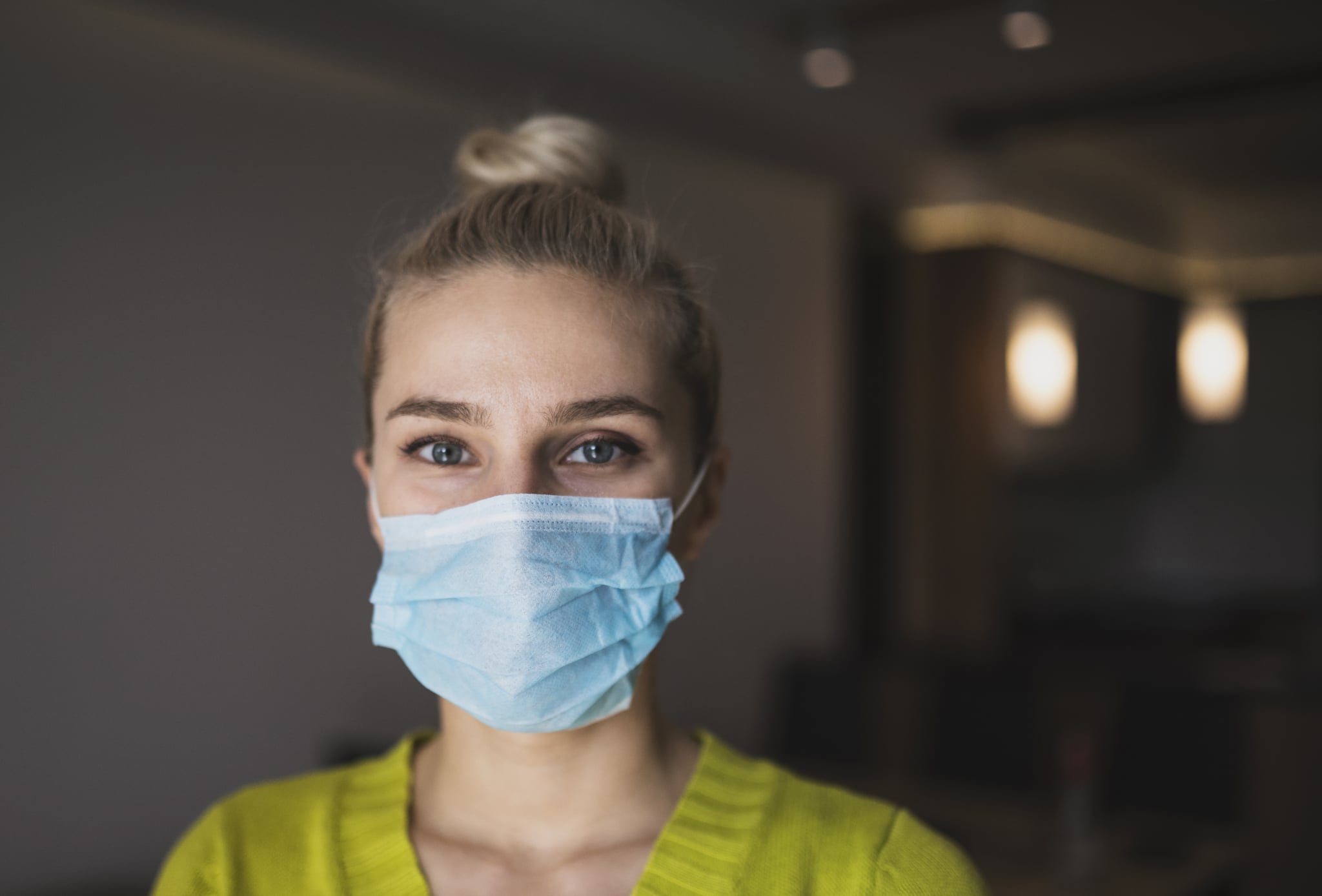 woman with protective mask at home under quarantine