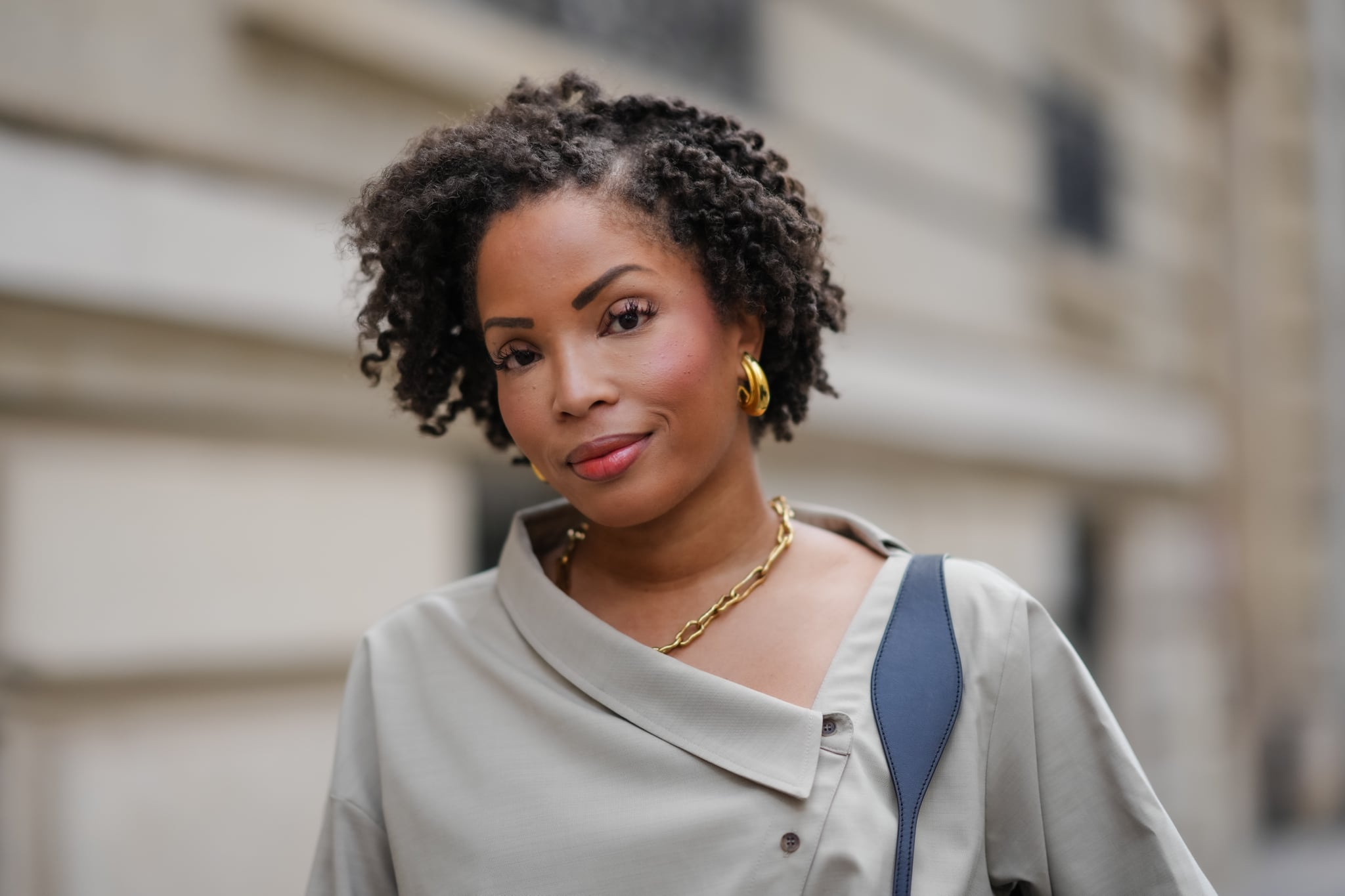 PARIS, FRANCE - MAY 20: Ellie Delphine wears golden earrings, a necklace from Missoma a beige oversized off-shoulder top / shirt from The Frankie Shop, during a street style fashion photo session, on May 20, 2024 in Paris, France. (Photo by Edward Berthelot/Getty Images) curly hair tips